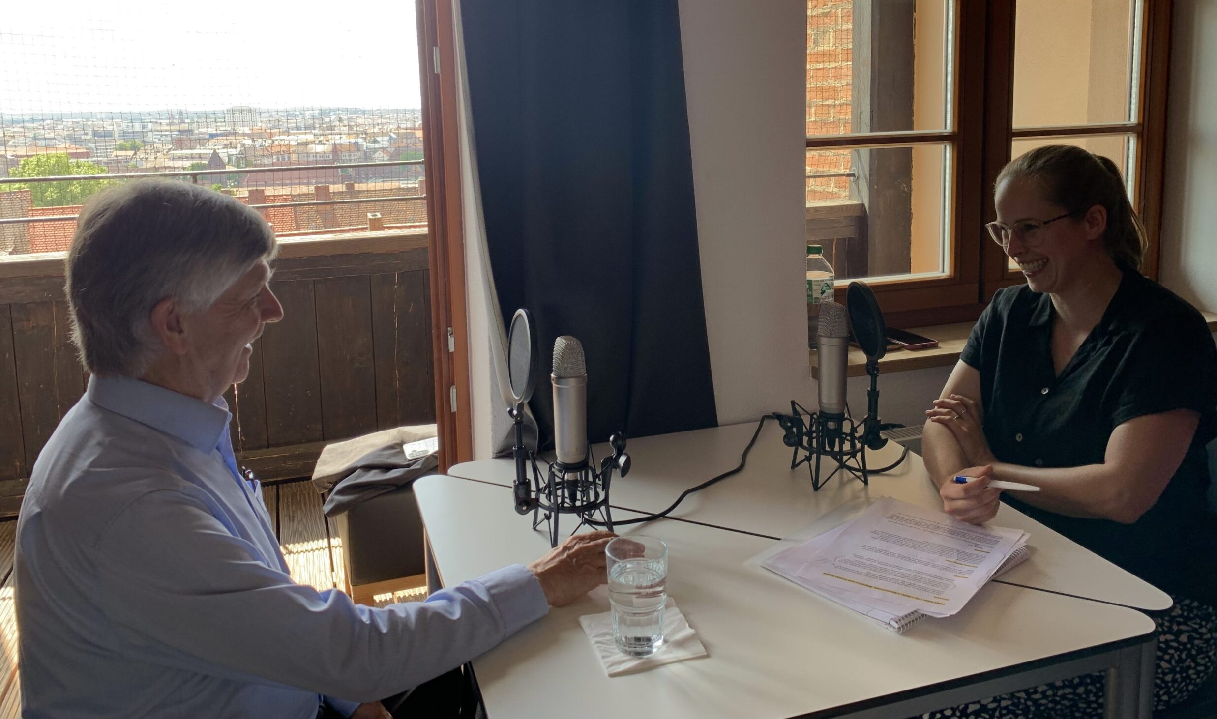 Walter Kälin and Johanna Günther laughing and recording the podcast.